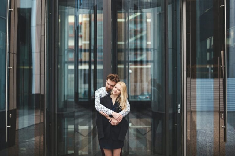 Love Story. The guy hugs the girl. Glass building